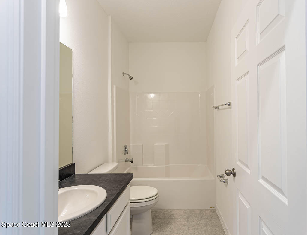 174 Compass Titusville, FL 32796 - Photo 29 of 32 a bathroom with a granite countertop sink toilet a mirror and shower