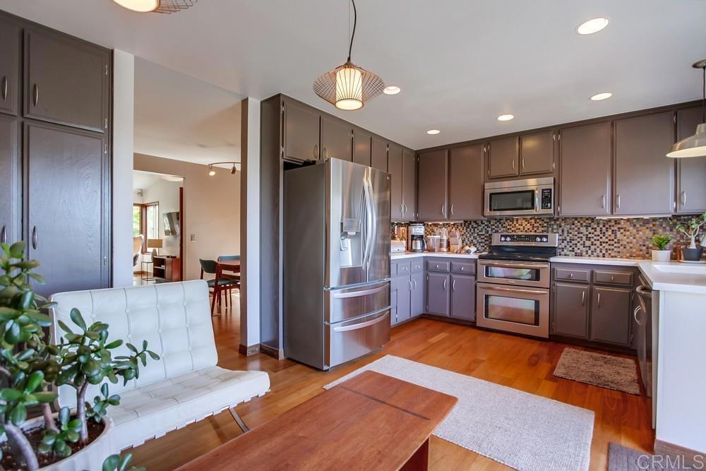 428 Compass Road Oceanside, CA 92054 - Photo 6 of 13 a kitchen with granite countertop stainless steel appliances and wooden cabinets