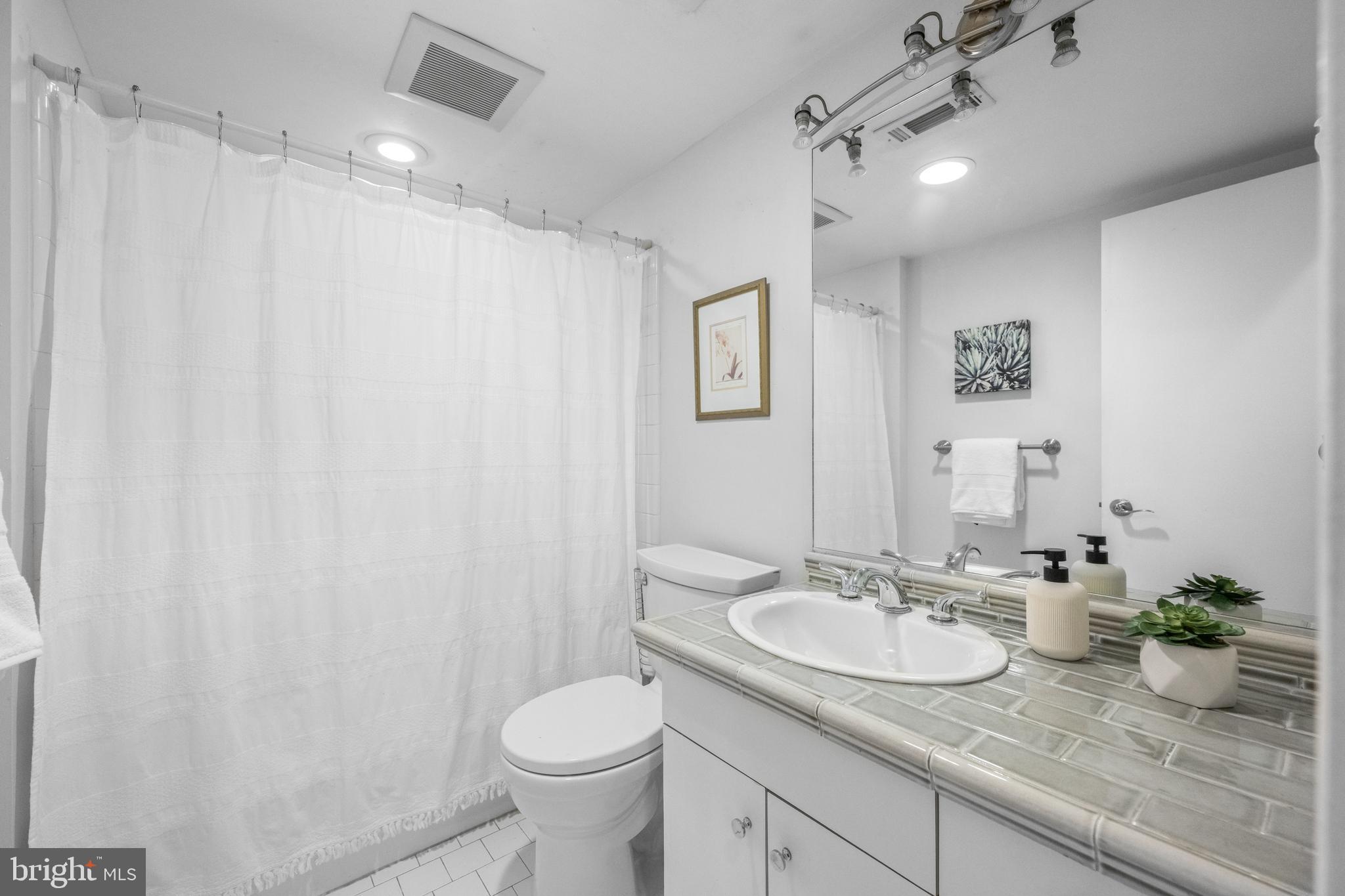 303 Spruce Street Philadelphia, PA 19106 - Photo 17 of 30 a bathroom with a granite countertop sink and a mirror
