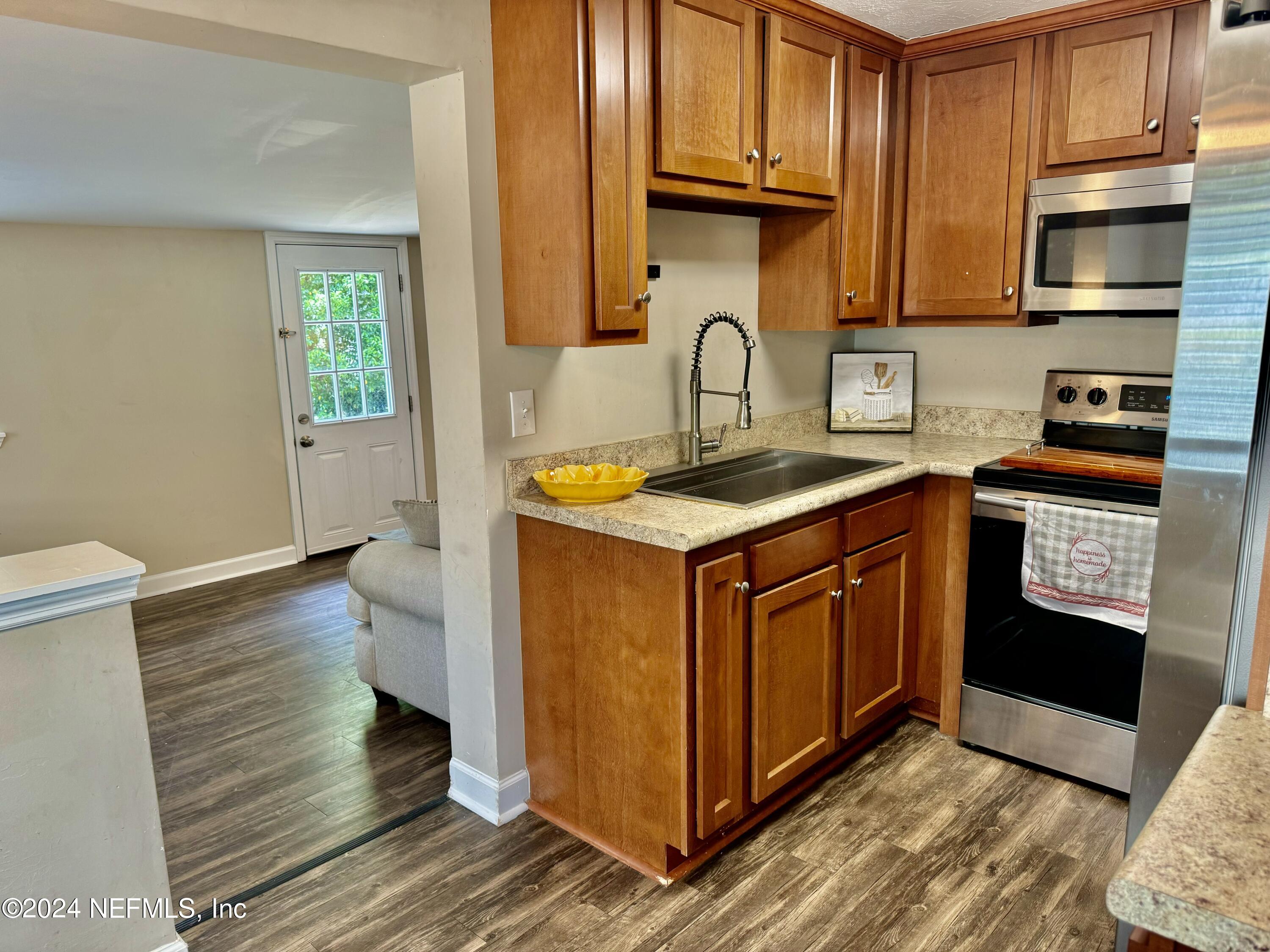 398 Gwinnett Road Orange Park, FL 32073 - Photo 12 of 40 a kitchen with stainless steel appliances granite countertop a sink stove and cabinets