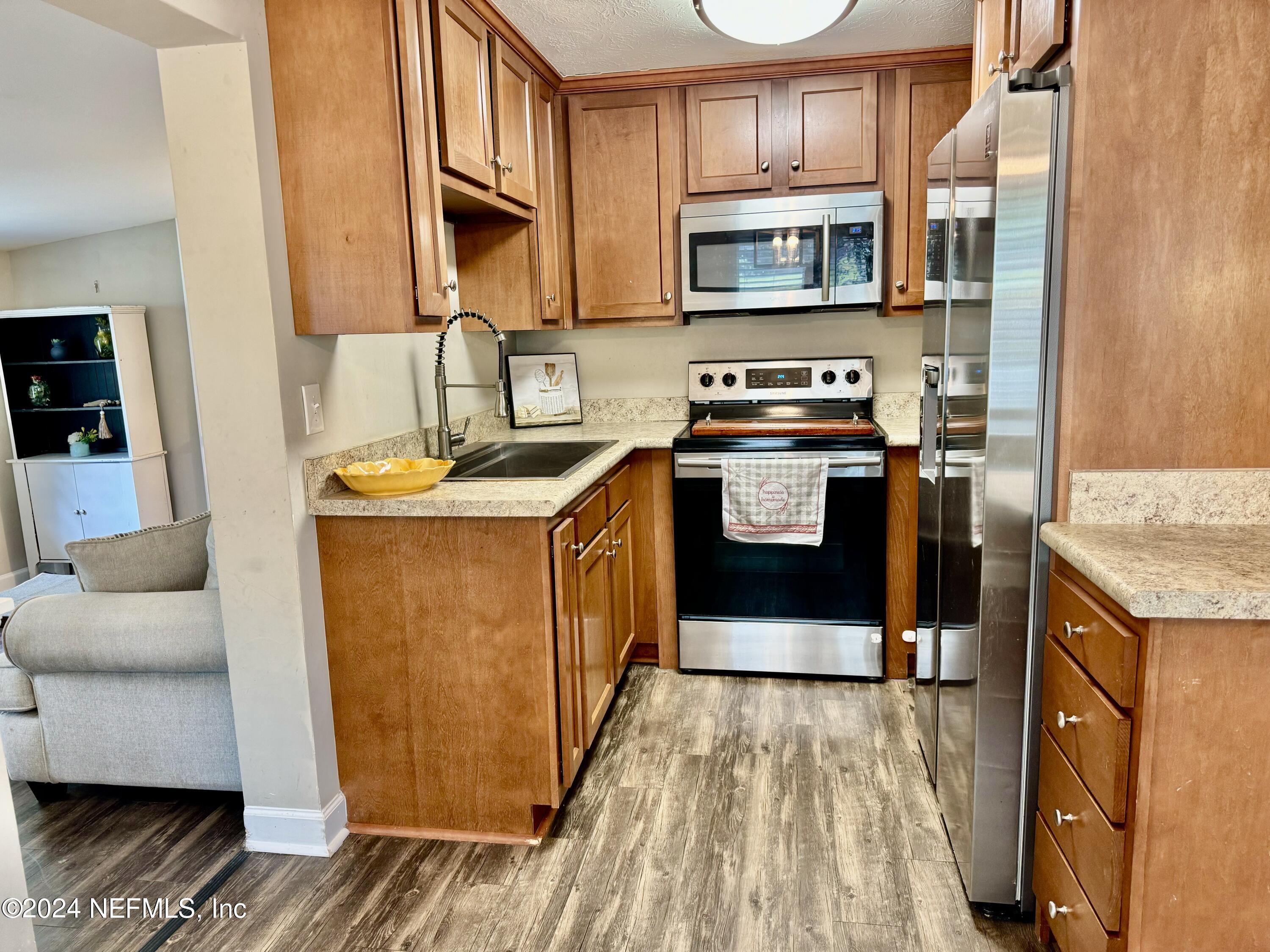 398 Gwinnett Road Orange Park, FL 32073 - Photo 24 of 40 a kitchen with stainless steel appliances granite countertop a stove a sink and a microwave