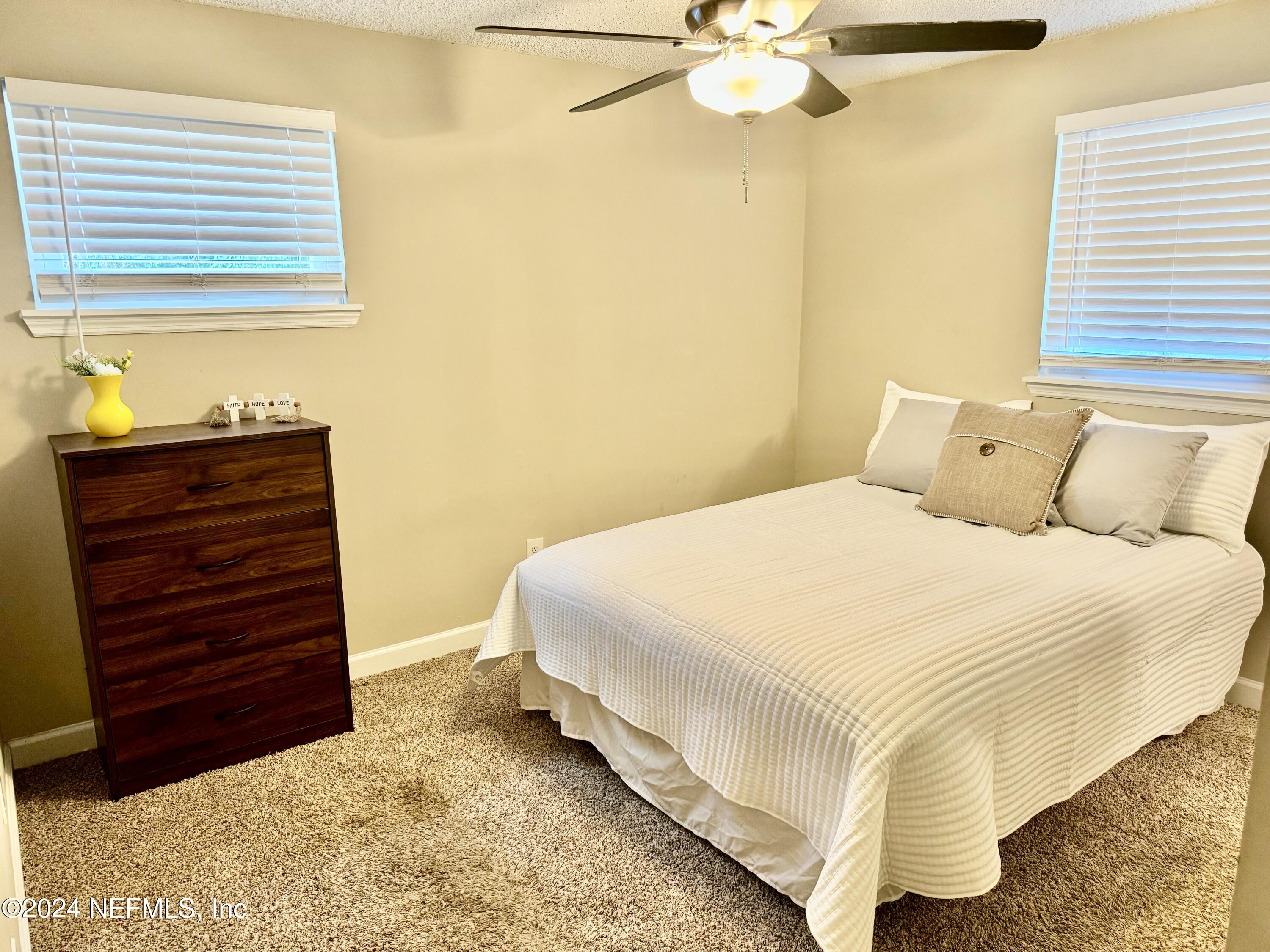 398 Gwinnett Road Orange Park, FL 32073 - Photo 27 of 40 a bedroom with a bed and a chandelier