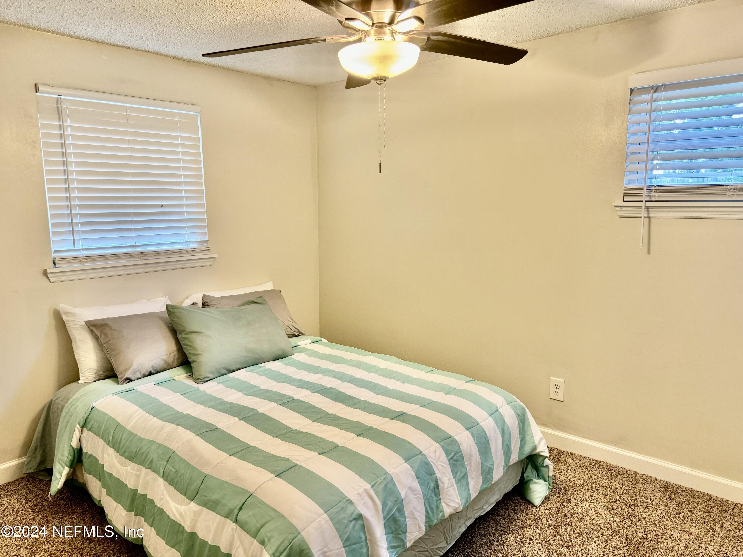 398 Gwinnett Road Orange Park, FL 32073 - Photo 32 of 40 a bedroom with a bed and a chandelier