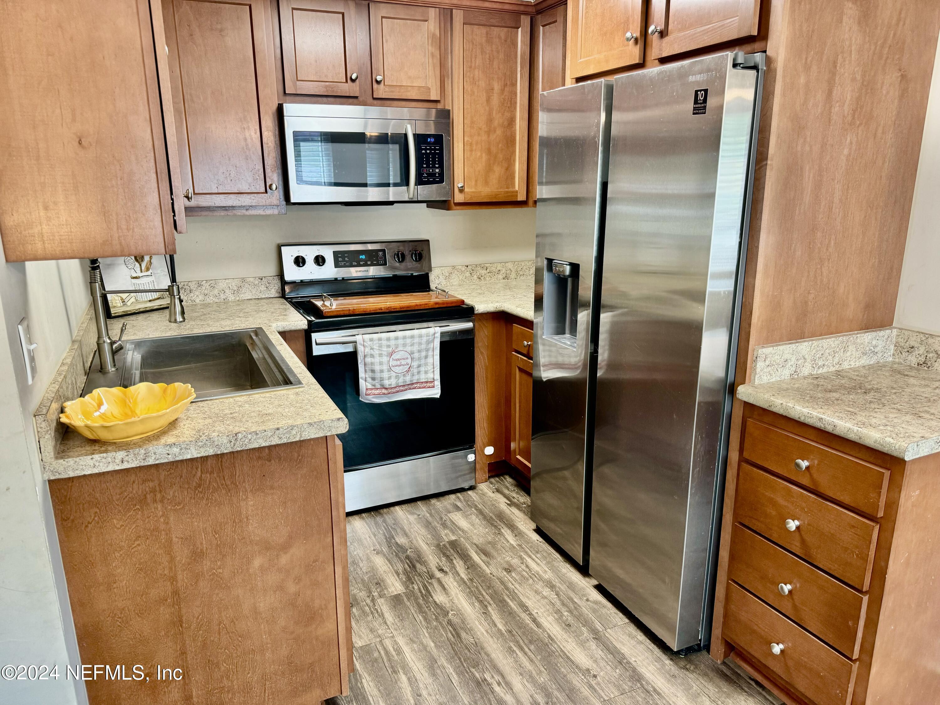 398 Gwinnett Road Orange Park, FL 32073 - Photo 10 of 40 a kitchen with granite countertop a refrigerator and a sink
