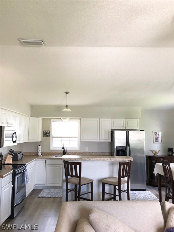 8133 Albatross Road Fort Myers, FL 33967 - Photo 3 of 14 a kitchen with a table chairs refrigerator and cabinets