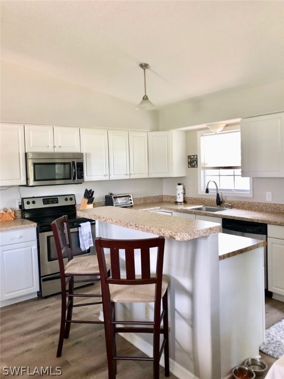 8133 Albatross Road Fort Myers, FL 33967 - Photo 4 of 14 a kitchen with stainless steel appliances granite countertop a table chairs microwave and sink