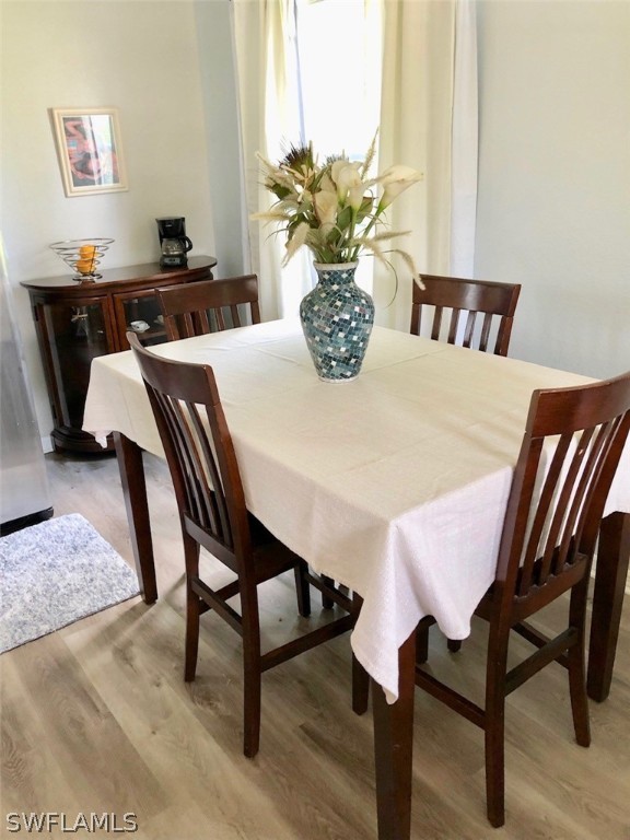 8133 Albatross Road Fort Myers, FL 33967 - Photo 5 of 14 a dining room with furniture and wooden floor