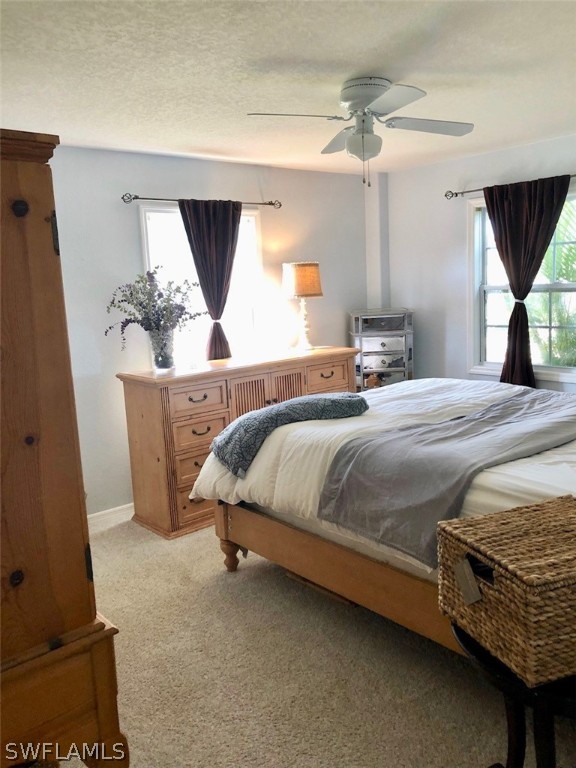 8133 Albatross Road Fort Myers, FL 33967 - Photo 6 of 14 a bedroom with a bed a mirror on dresser and a window
