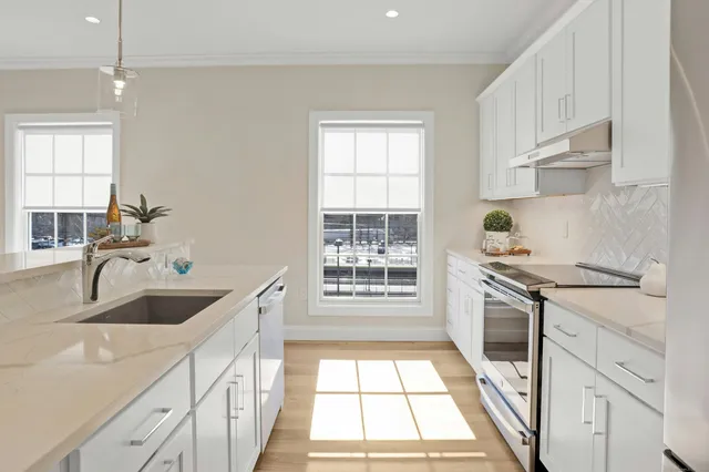 a kitchen with granite countertop a sink stainless steel appliances and cabinets