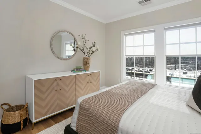 a bedroom with a bed mirror and window