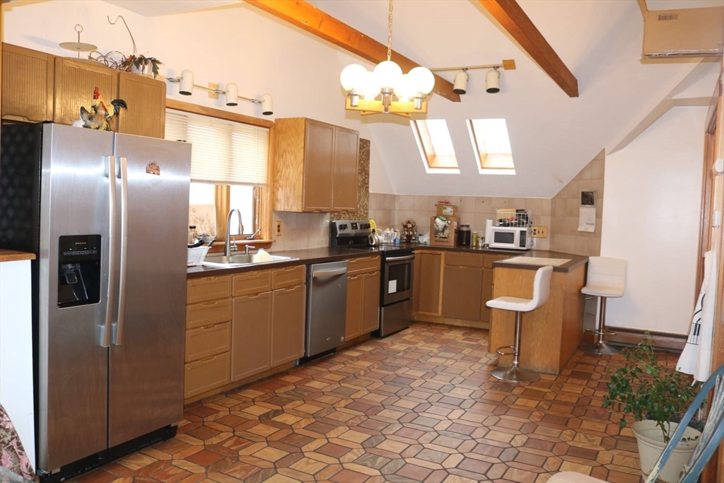 586 Franklin Street, Unit 2 Worcester, MA 01604 - Photo 2 of 7 a kitchen with stainless steel appliances a refrigerator a sink a stove and chairs