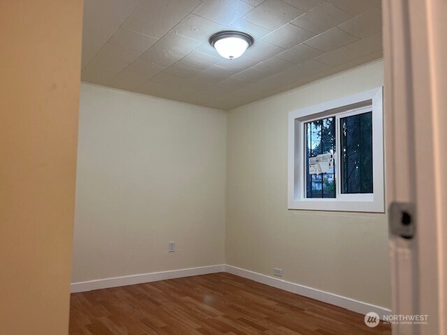 12524 Addison Street Southwest Lakewood, WA 98499 - Photo 2 of 20 a view of an empty room with wooden floor and a window