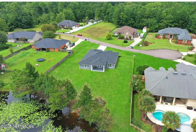 an aerial view of residential houses with outdoor space and street view