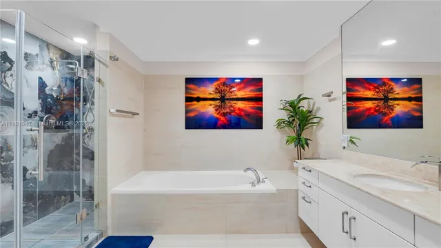 a bathroom with a granite countertop tub a sink and glass door shower