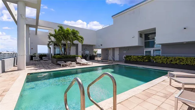 a view of a swimming pool with chairs and a table