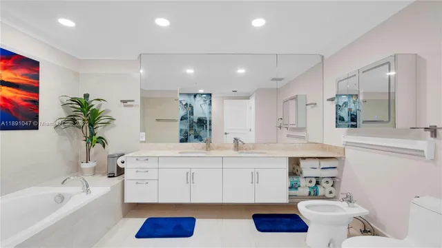 a bathroom with a bathtub a sink and a potted plant