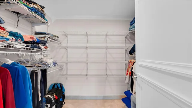 a view of walk in closet with clothes and shoes