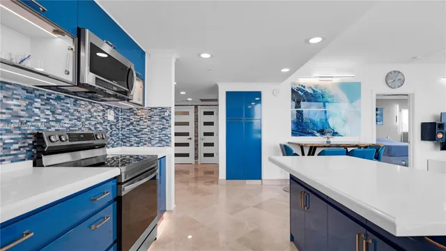 a kitchen with stainless steel appliances a stove a sink a microwave a refrigerator a stove and cabinets