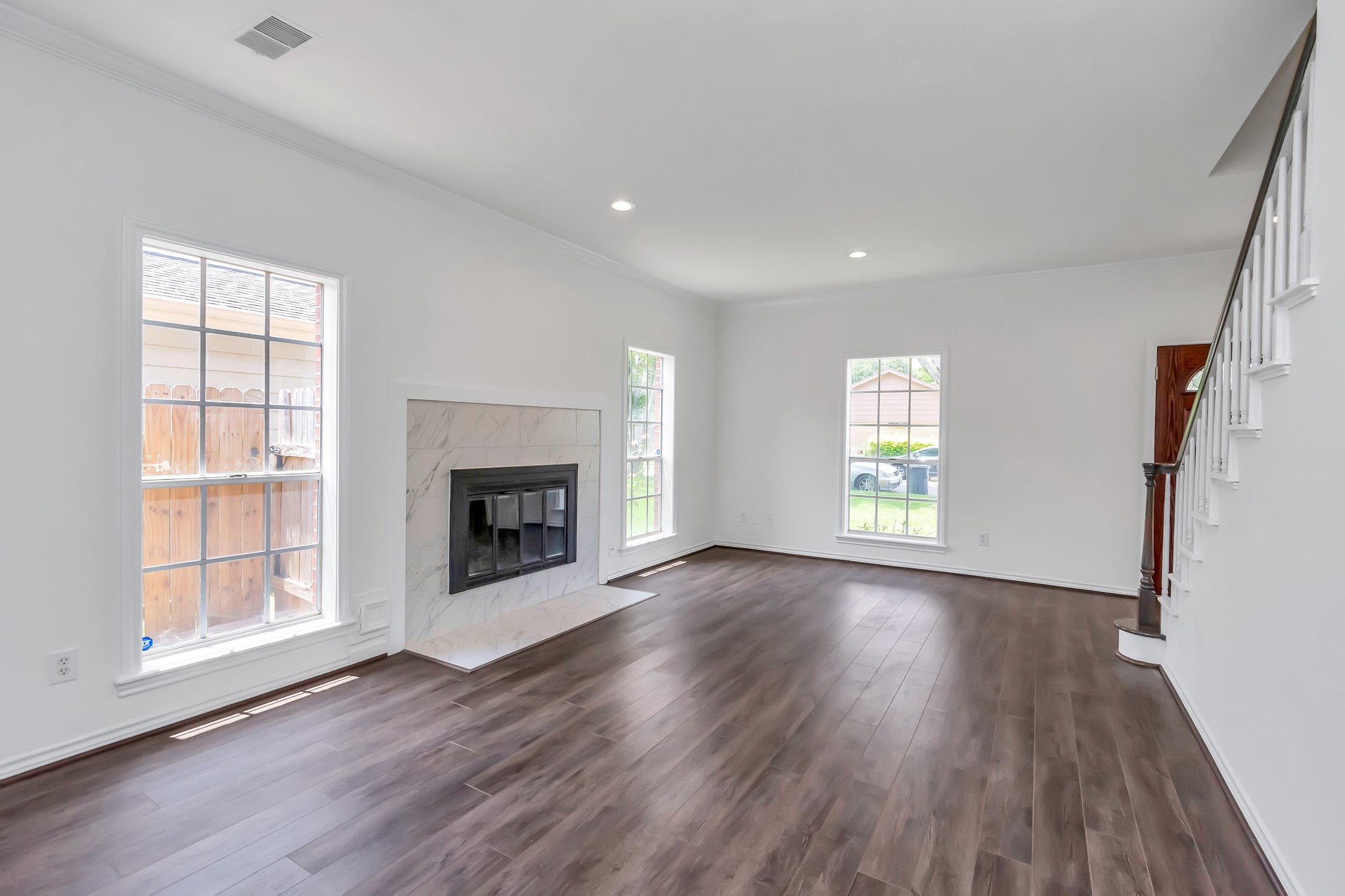 12818 Chamberlain Drive Houston, TX 77077 - Photo 11 of 32 an empty room with wooden floor fireplace and windows