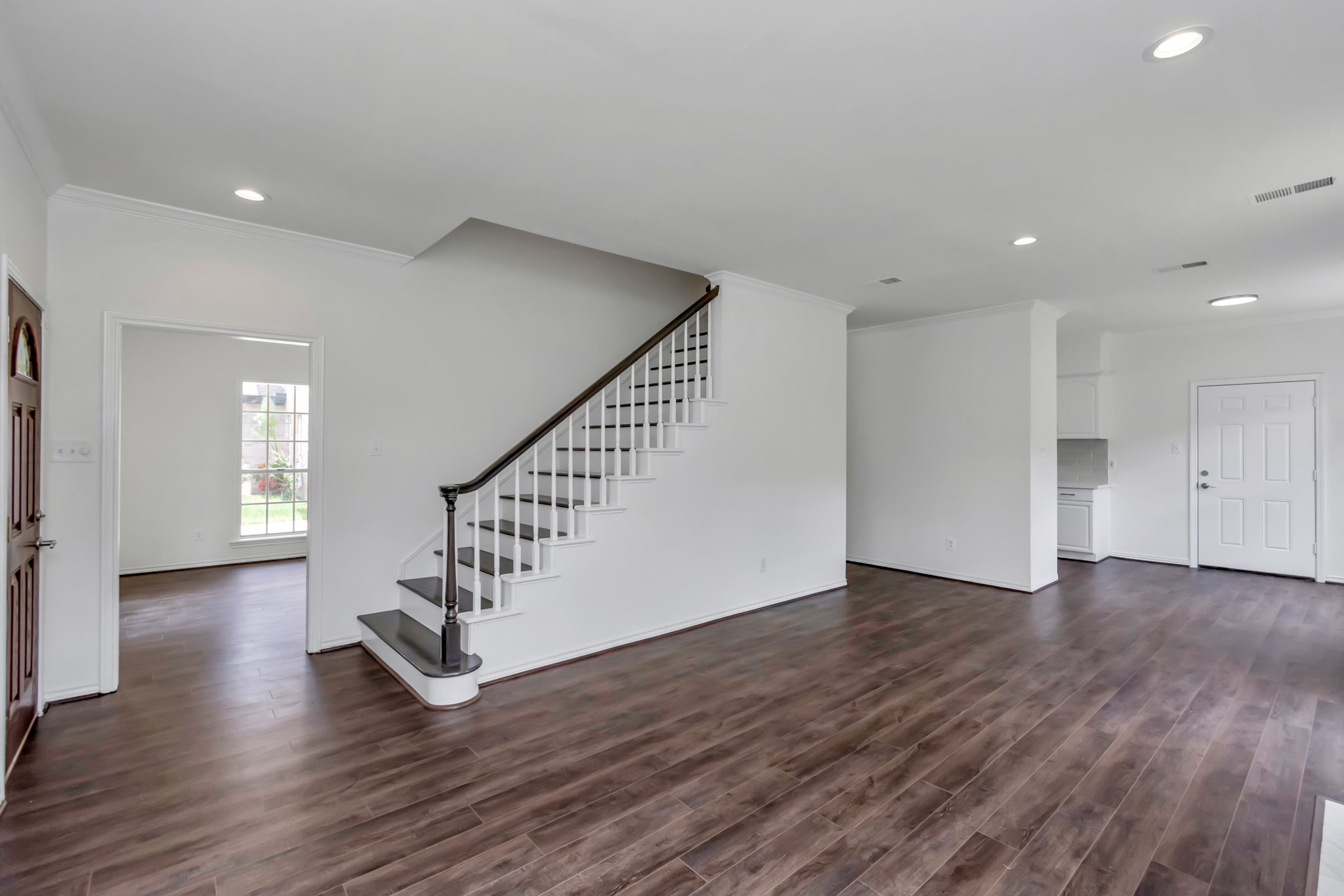 12818 Chamberlain Drive Houston, TX 77077 - Photo 13 of 32 a view of an empty room with wooden floor and stairs