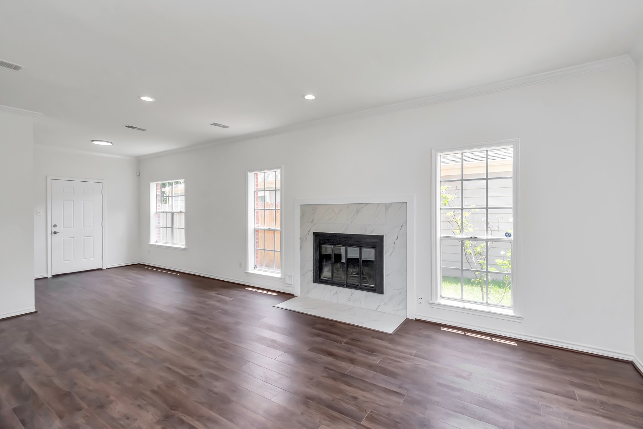 12818 Chamberlain Drive Houston, TX 77077 - Photo 14 of 32 an empty room with wooden floor fireplace and windows