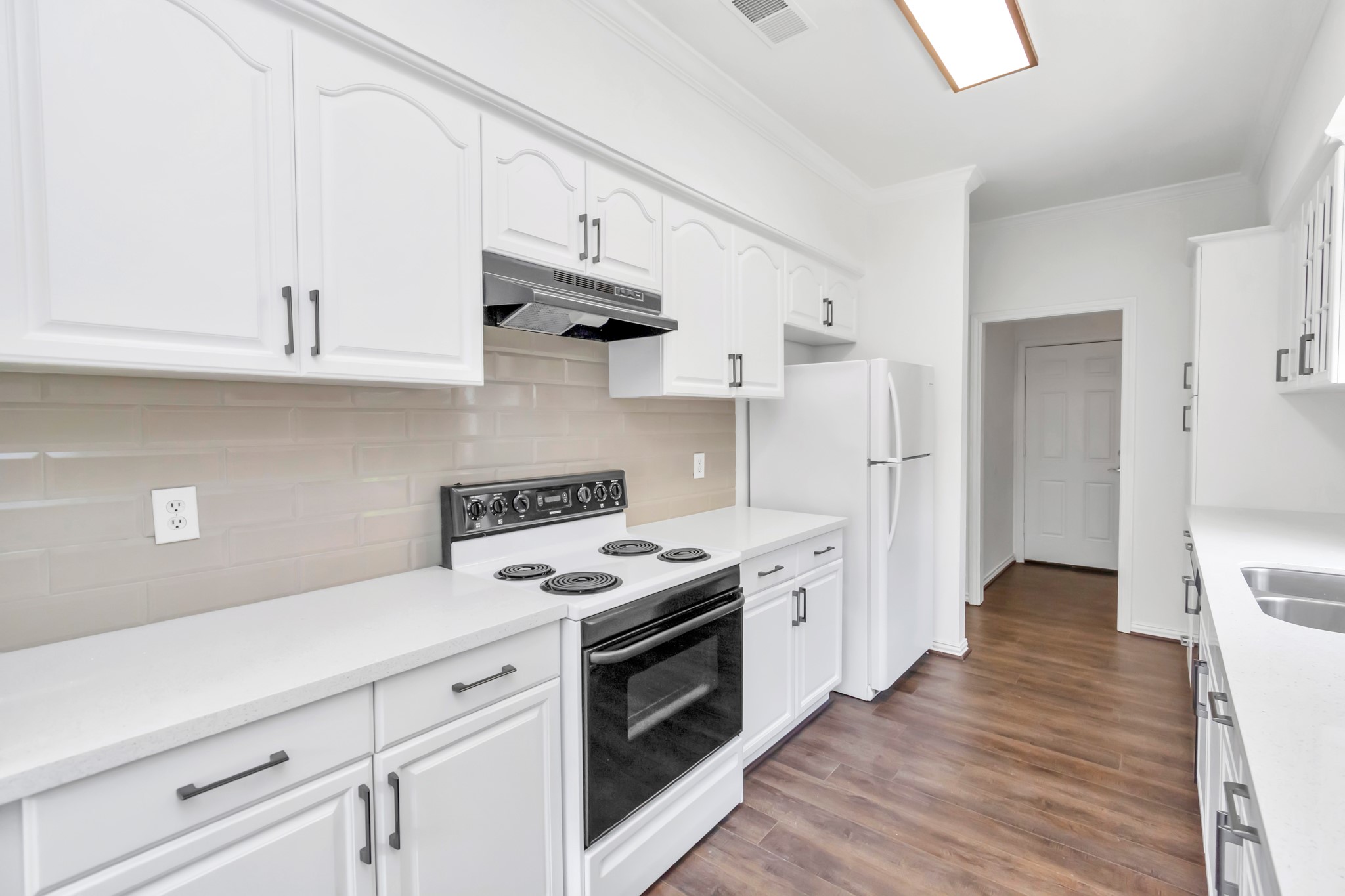 12818 Chamberlain Drive Houston, TX 77077 - Photo 17 of 32 a kitchen with stainless steel appliances white cabinets and a stove a refrigerator
