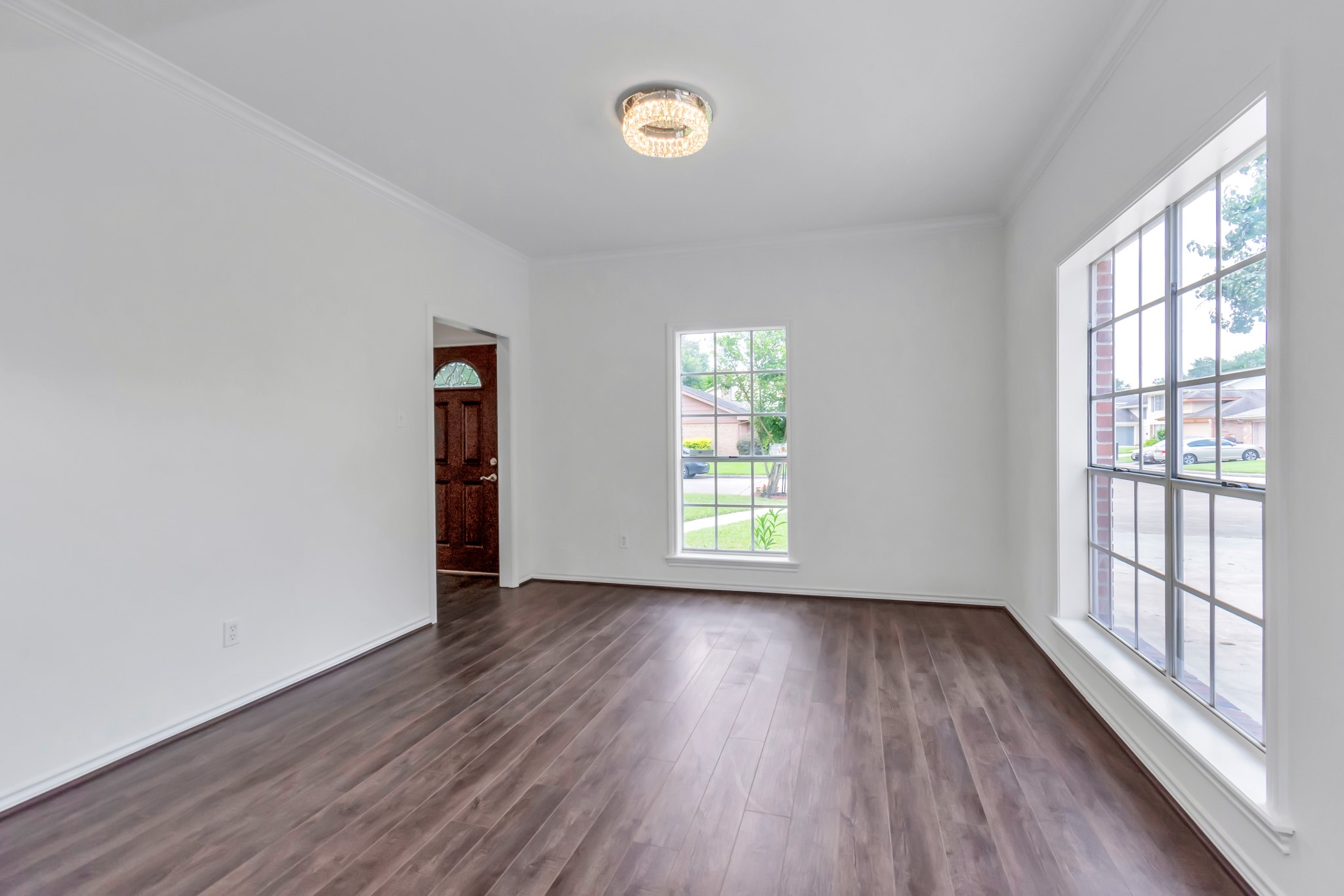 12818 Chamberlain Drive Houston, TX 77077 - Photo 7 of 32 an empty room with wooden floor and windows