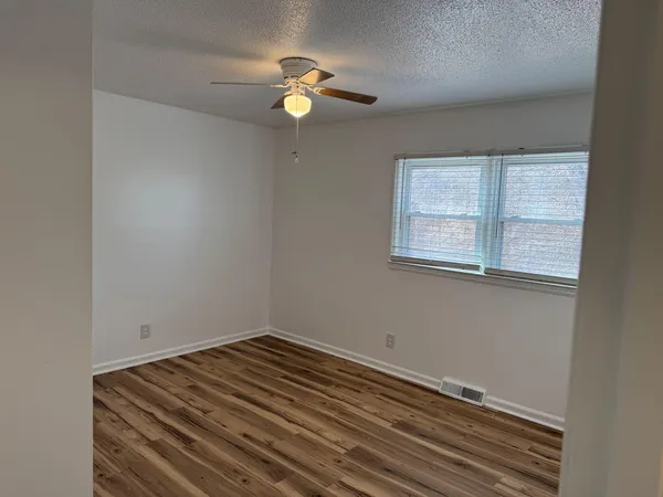 a view of a room with wooden floor and fan
