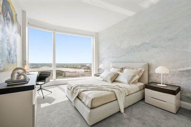 a bedroom with bed and a large window