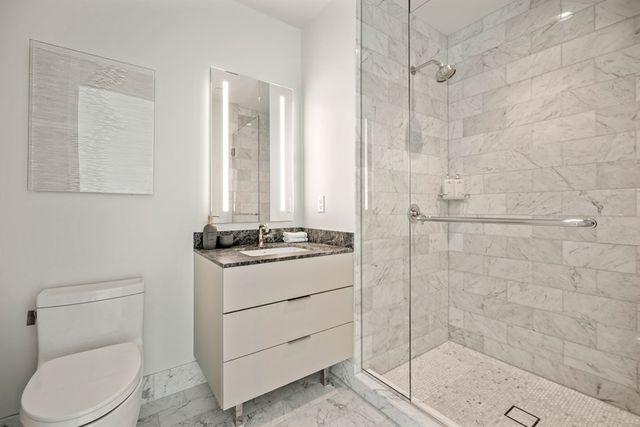 a bathroom with a sink a toilet and shower