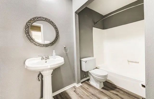 a bathroom with a sink toilet and a mirror