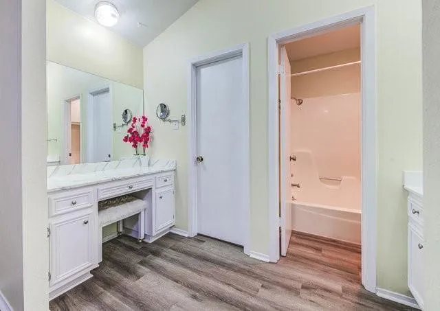 a bathroom with a sink vanity and tub