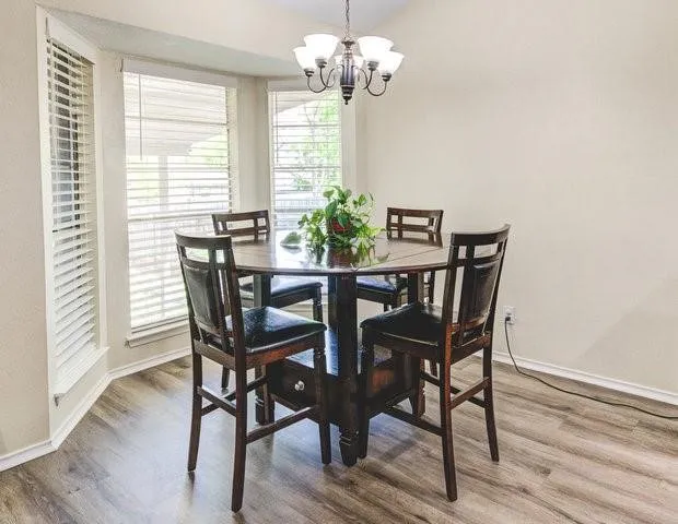 a view of a dining room with furniture a chandelier and wooden floor
