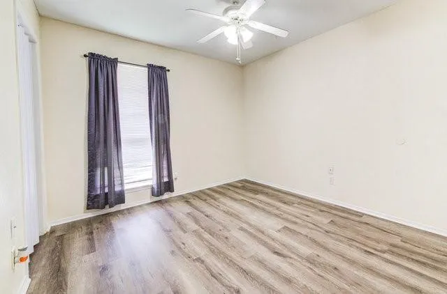 an empty room with fan and entrance