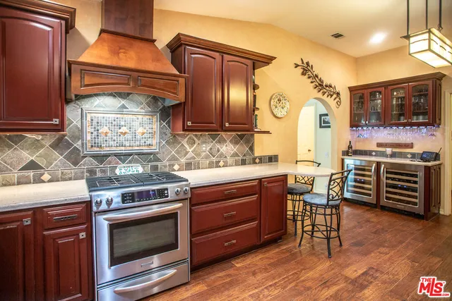 a kitchen with stainless steel appliances granite countertop a stove and a wooden cabinets