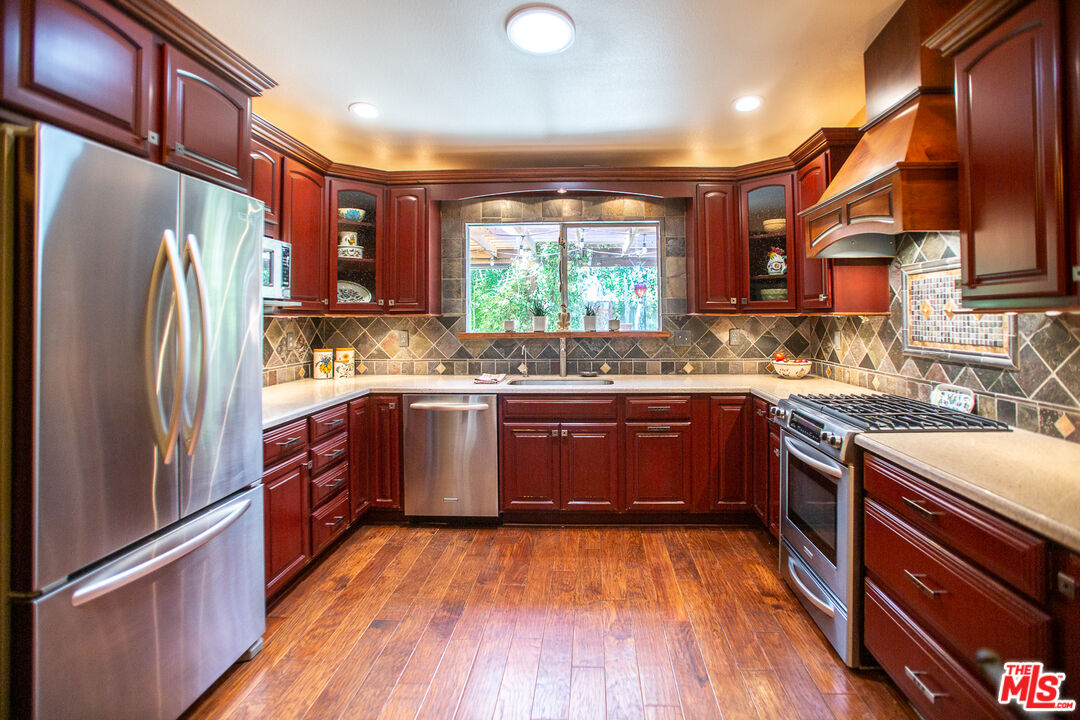 969 Vintage Way Los Alamos, CA 93440 - Photo 8 of 59 a kitchen with stainless steel appliances granite countertop a refrigerator a sink dishwasher a stove and white countertops with wooden floor