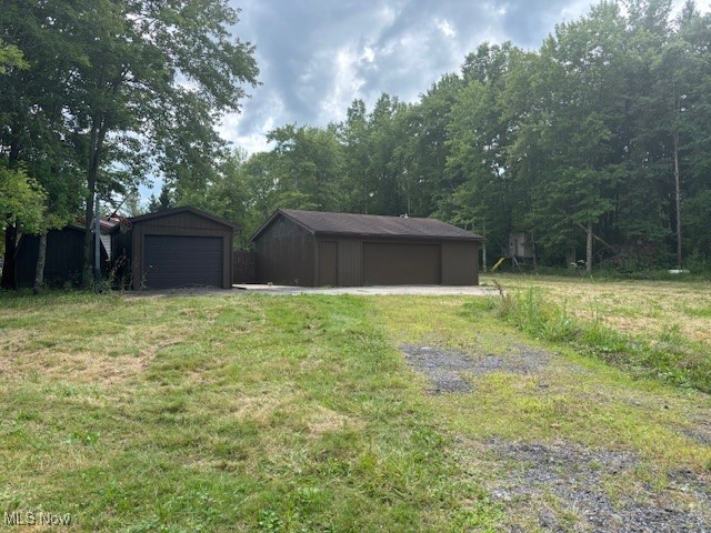 3077 Anderson Anthony Road Northwest Warren, OH 44481 - Photo 3 of 31 View of grassy yard featuring 2 detached garages a shed.