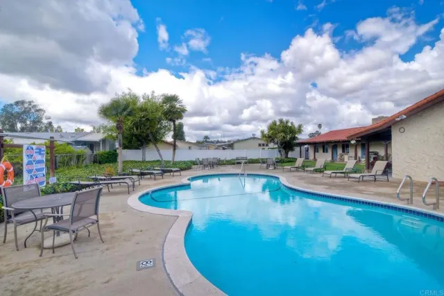 a view of a swimming pool with a table and chairs in patio
