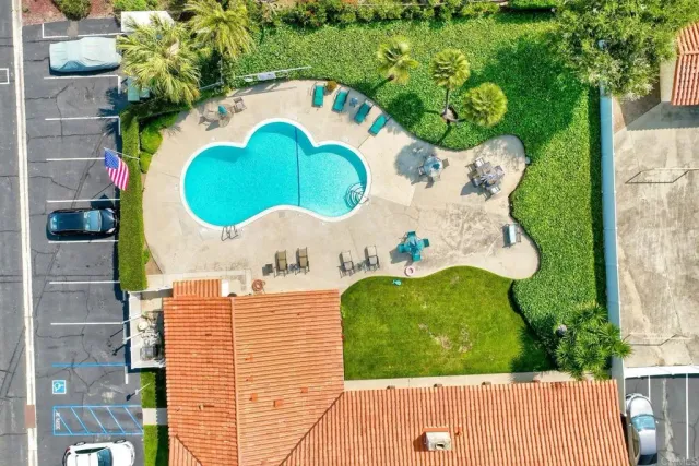 swimming pool view with a garden and seating space