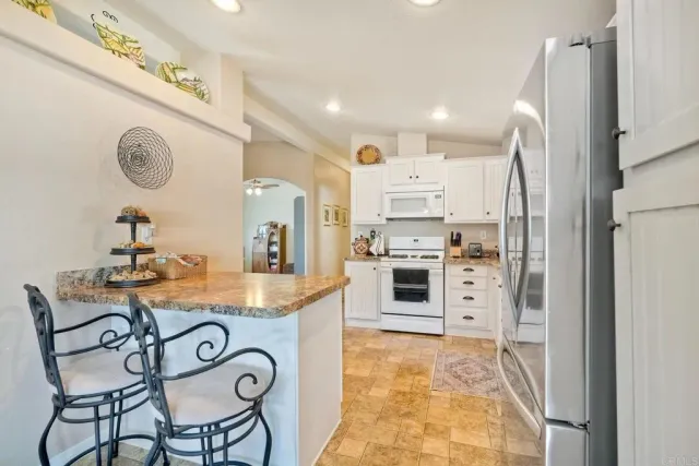 a kitchen with stainless steel appliances granite countertop a sink and a refrigerator