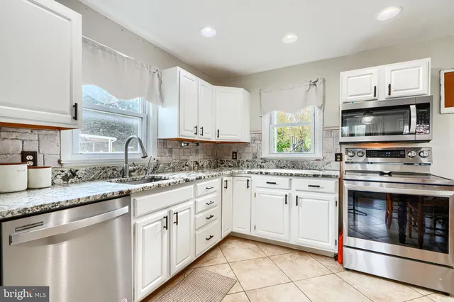 a kitchen with stainless steel appliances granite countertop a stove sink and microwave