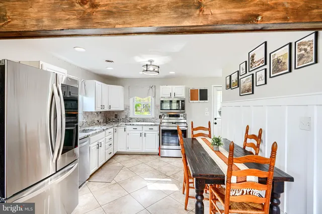 a kitchen with stainless steel appliances granite countertop a refrigerator and a stove top oven