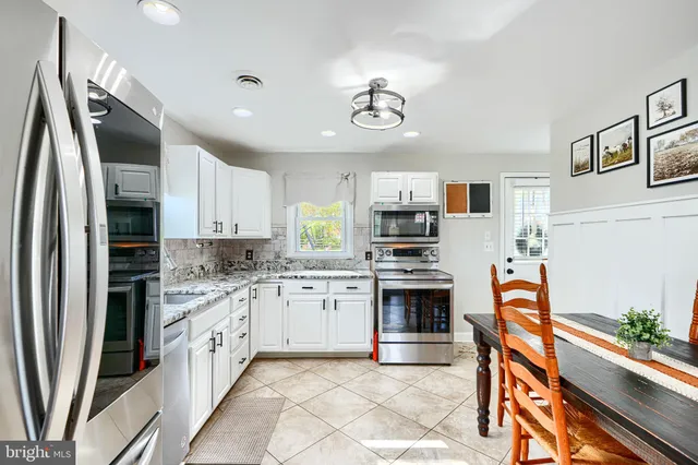 a kitchen with stainless steel appliances granite countertop a refrigerator sink and stove