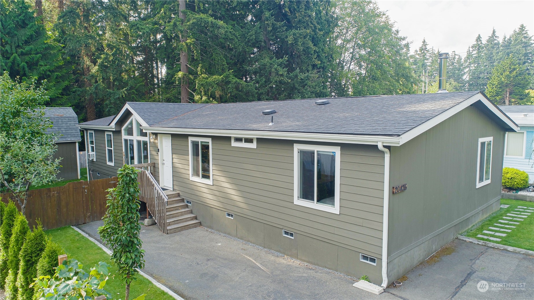a aerial view of house with yard and trees in the background