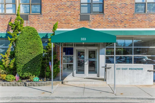 a front view of a building with a garden and plants