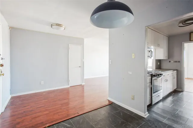 a kitchen with granite countertop white cabinets and white appliances