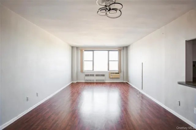 a view of a room with wooden floor and window