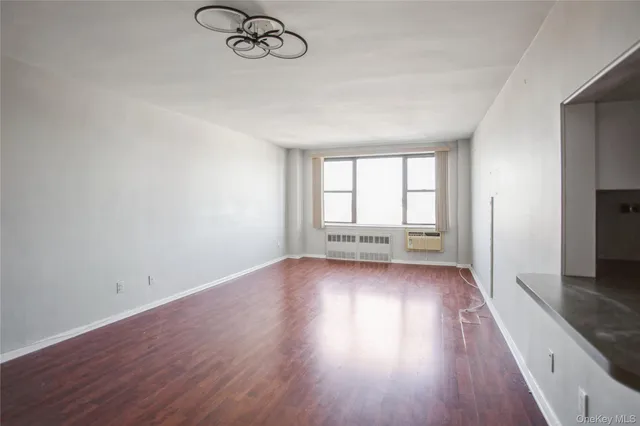 a view of a room with wooden floor and window