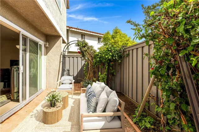 a view of a patio with table and chairs potted plants with wooden floor and fence