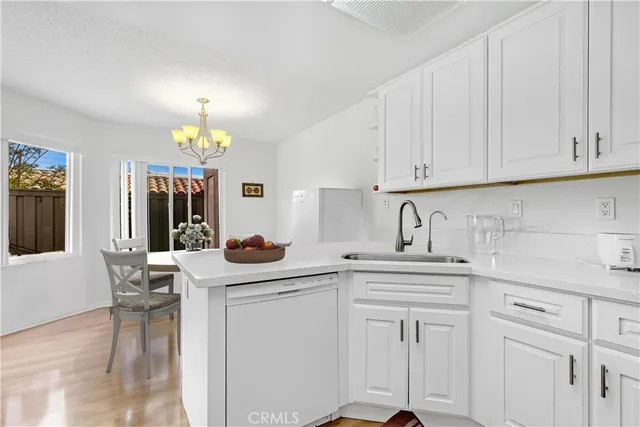 a kitchen with white cabinets and sink